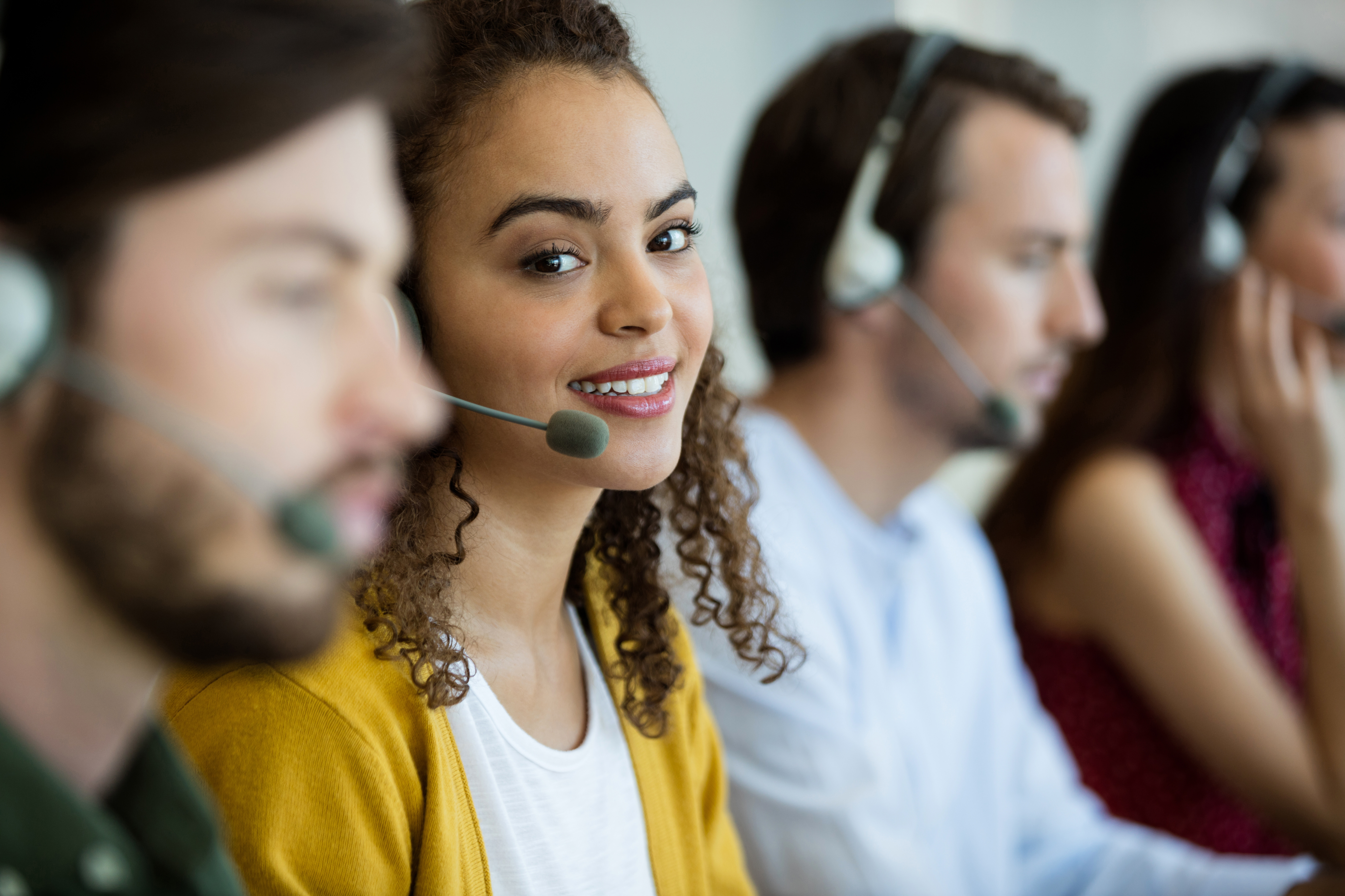 Customer service executive working at office with telephone headset on.