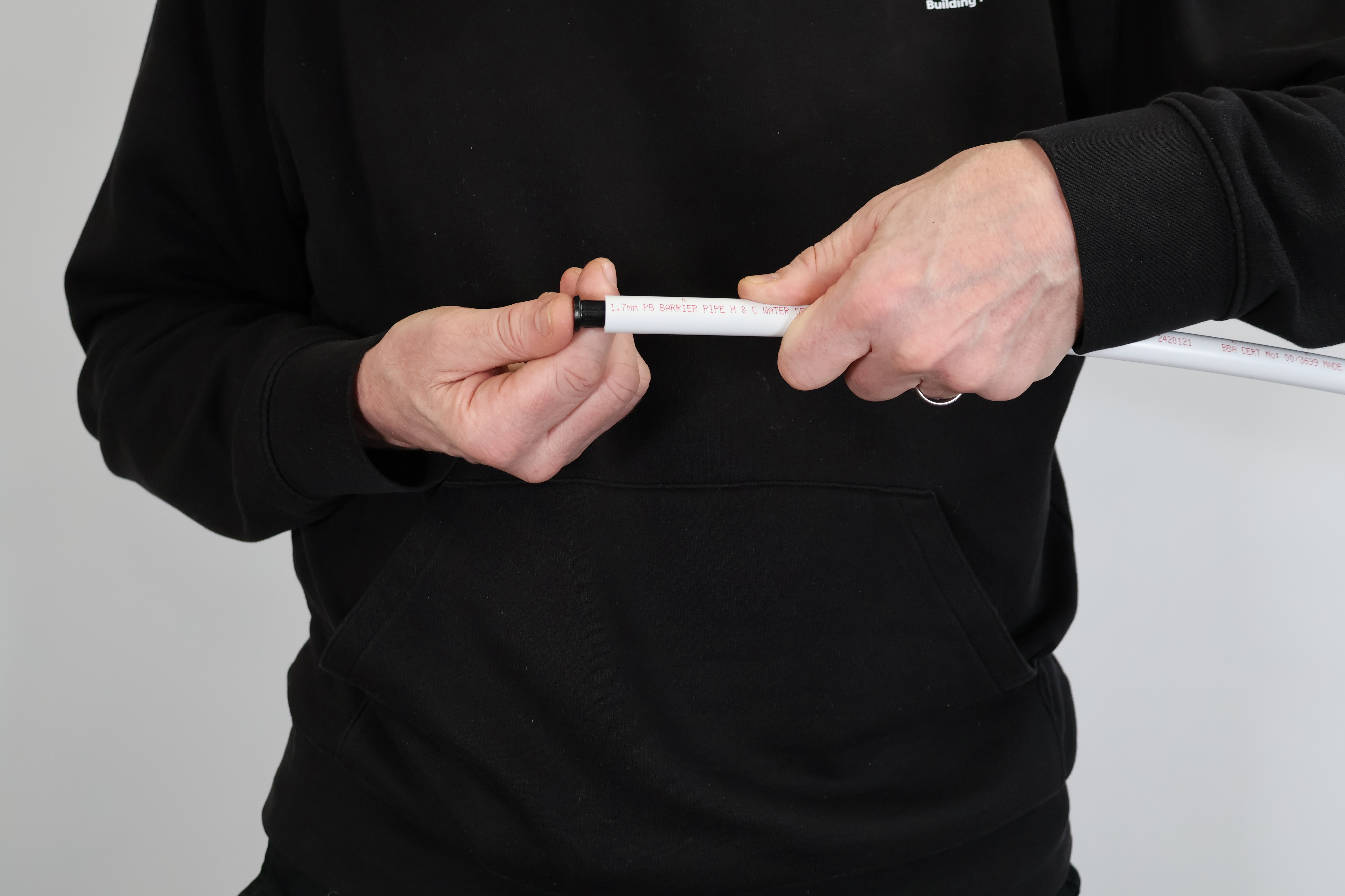 Close-up of a pipe stiffener being fitted into a plastic plumbing pipe. Inserting a stiffener is essential for a secure seal in PolyPlumb and PolyMax fittings, preventing the pipe end from deforming under pressure.